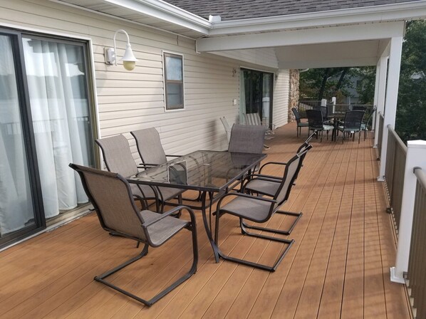 A covered outdoor patio with a glass-top table and six chairs.
