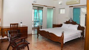 A bedroom with a wooden bed, a desk with chairs, a ladder, and an air conditioning unit. - Maya Service Apt (Dhaka)
