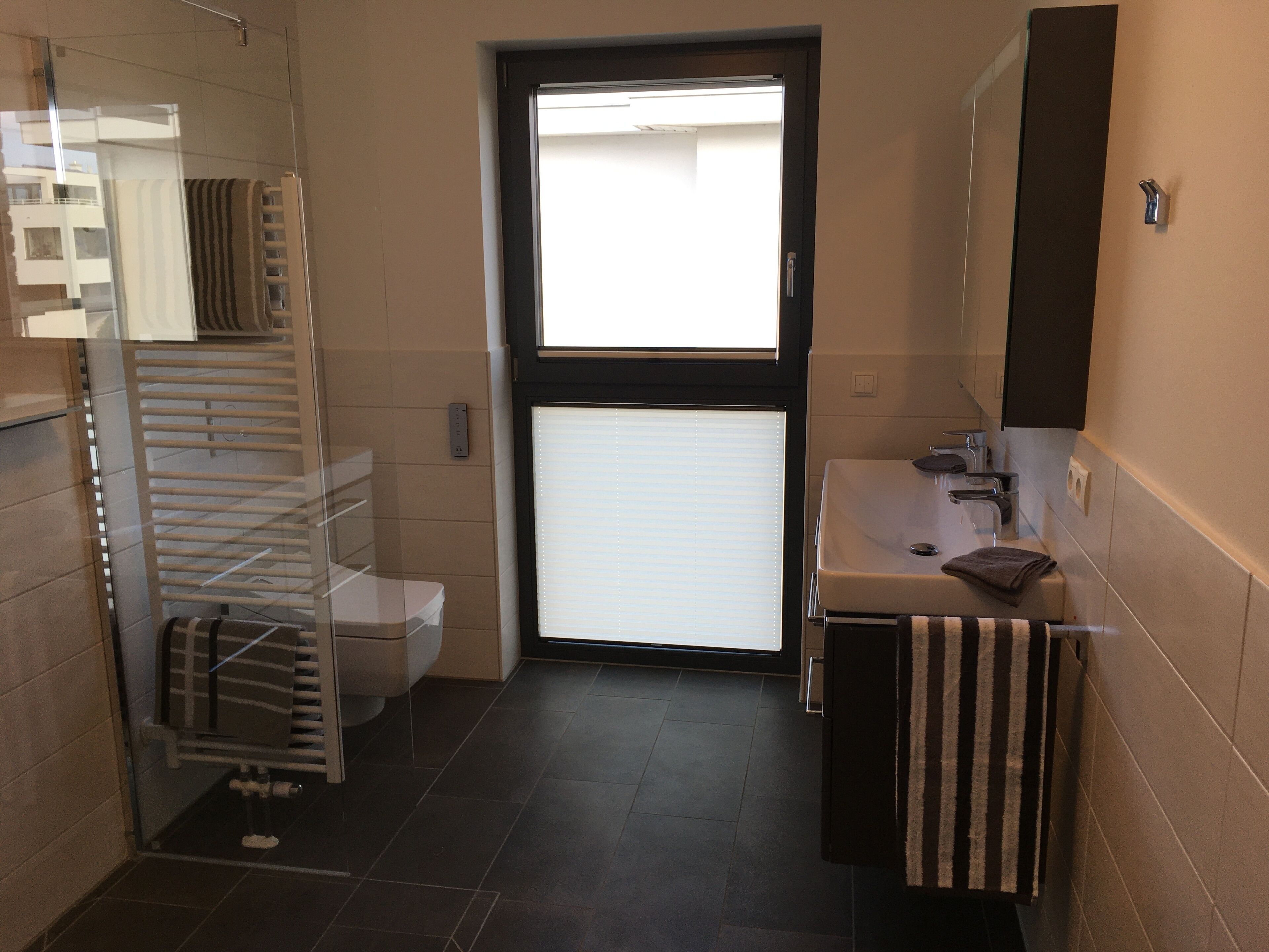 Une petite salle de bain comprenant des toilettes, un lavabo et un porte-serviettes.
