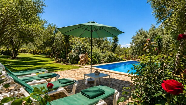 Zona de piscina con sillas de descanso y una sombrilla.
