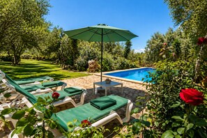 A pool area with lounge chairs and an umbrella. - Charming House - 6 pax, - Wifi Free - Sat TV - Private Salat Pool (Manacor)