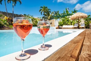 Una piscina al aire libre, sombrillas, sillones reclinables de piscina