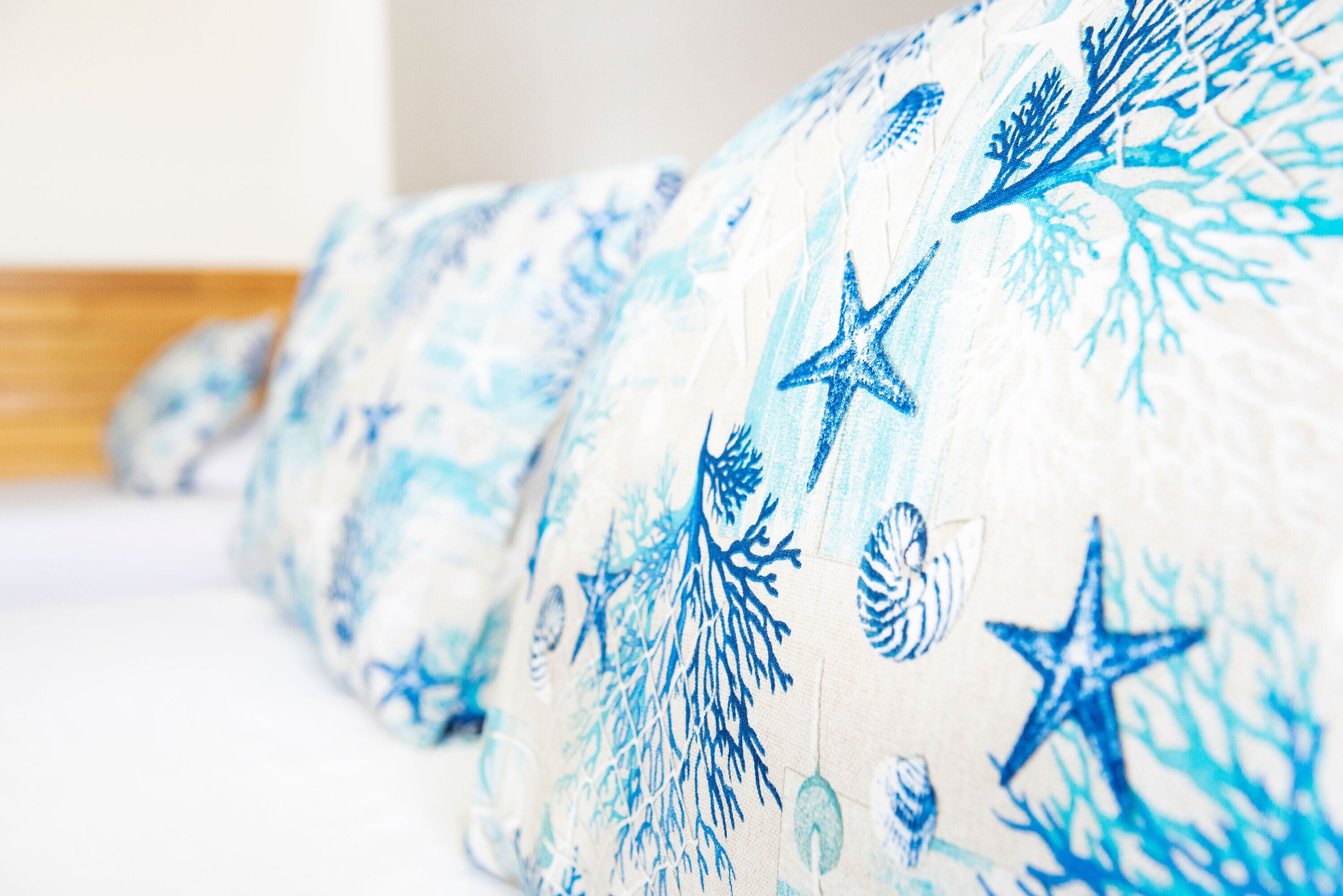 Primer plano de un tejido con un estampado azul y blanco, que incluye estrellas y criaturas marinas.