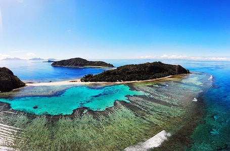 On the beach, sun-loungers, beach towels. Fijian family community stay in paradise.
