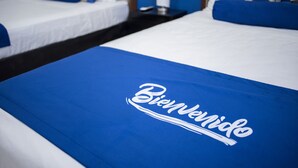 A hotel room with a bed featuring a blue bedspread with "Bienvenue" written on it. - La Estancia Apartments Mazatlan 2 (Mazatlán)