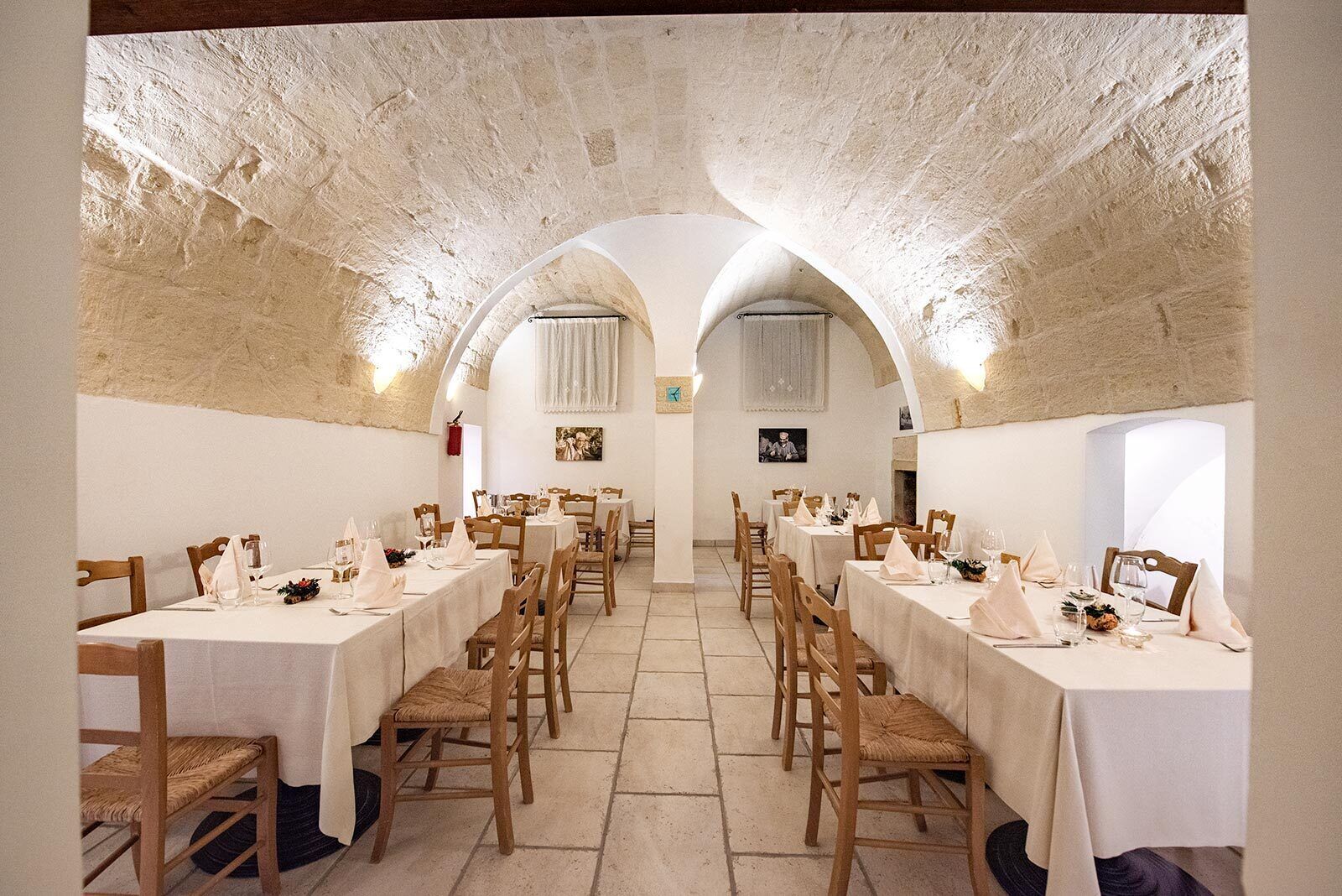 Un amplio comedor con techos abovedados y mesas dispuestas para una comida.