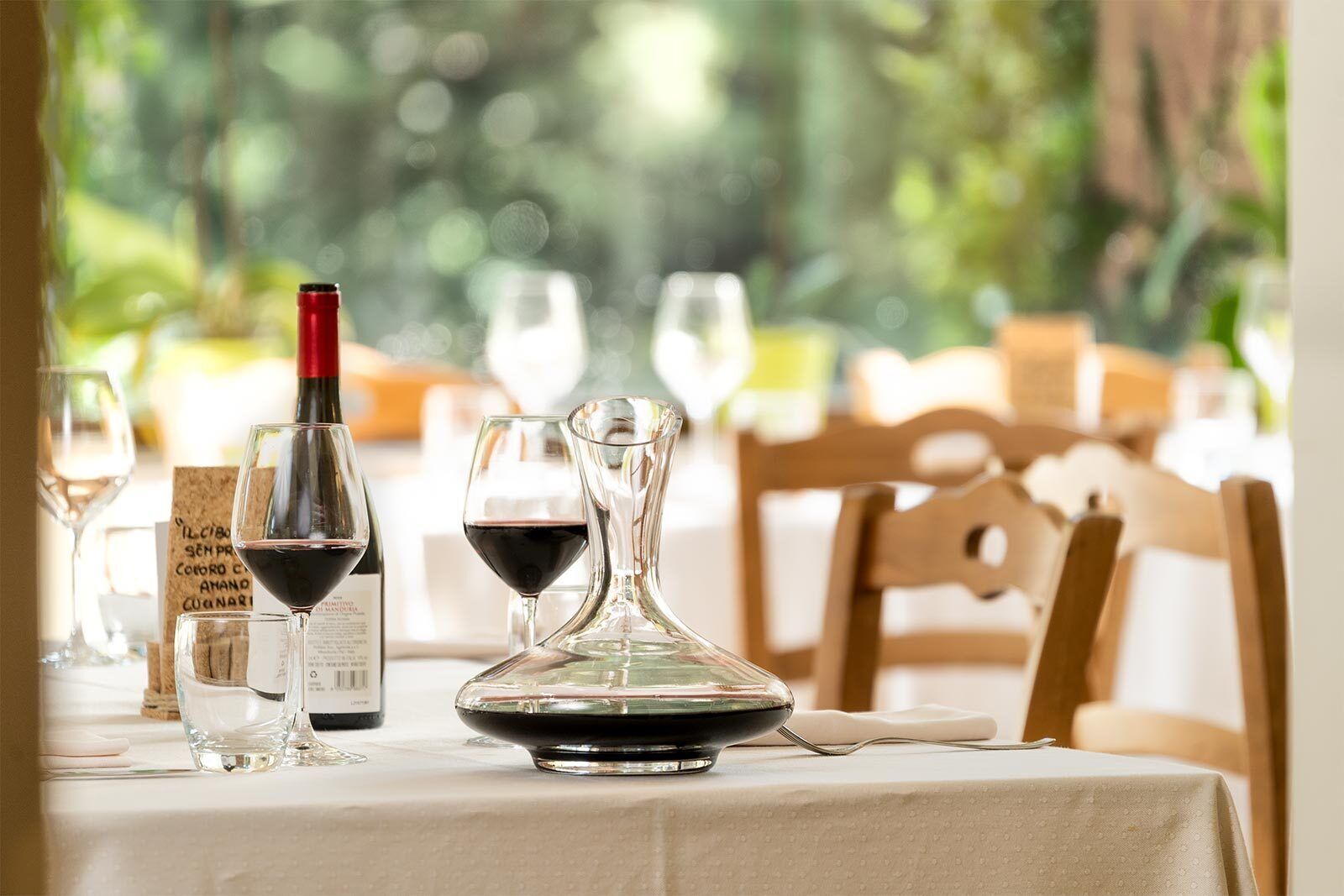 A table set for dining with wine glasses, a wine bottle, and a decanter.