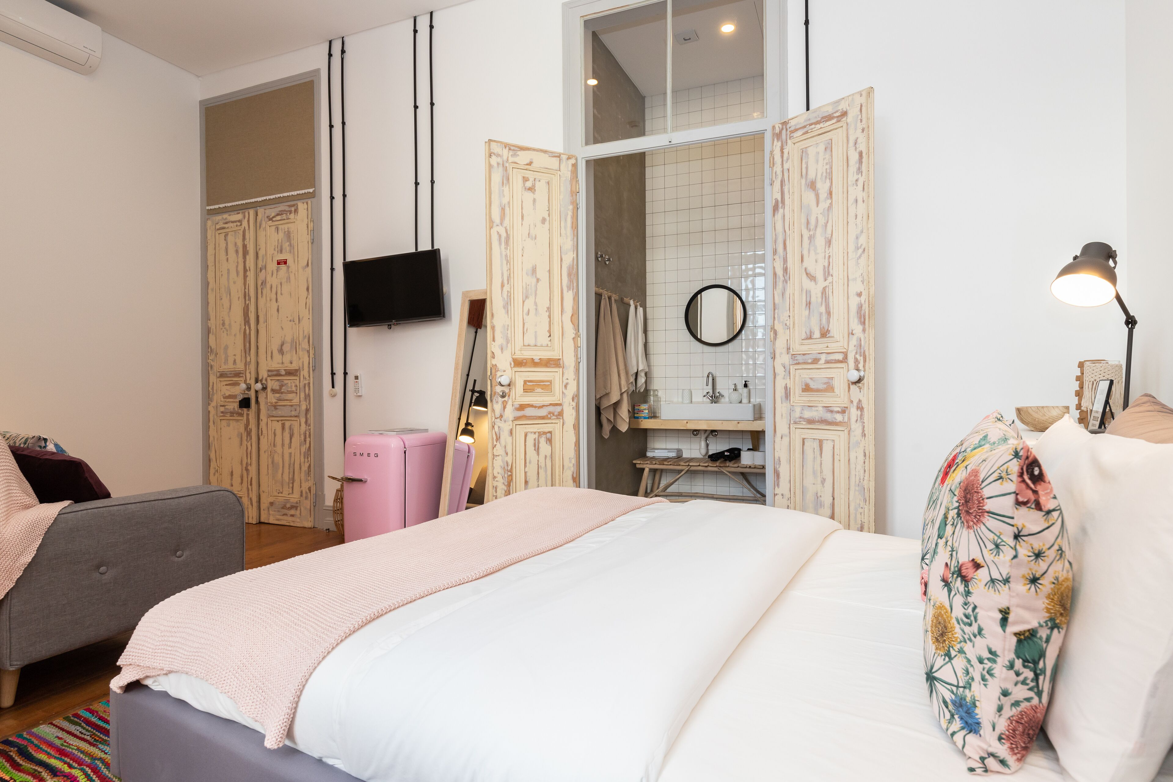 Un dormitorio con cama, cómoda, tocador y televisor.