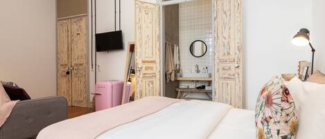 Un dormitorio con cama, cómoda, tocador y televisor.