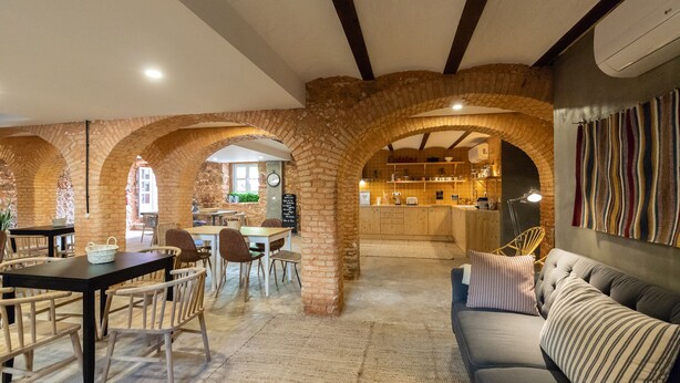 Un vaste espace dédié à la salle à manger, agrémenté d’arches en briques, d’un bar et d’un canapé.