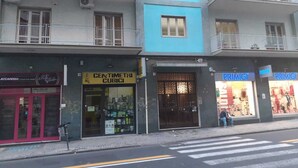 A street view with a blue building housing CENTIMETRI CUBICI and PRIMIGI stores.