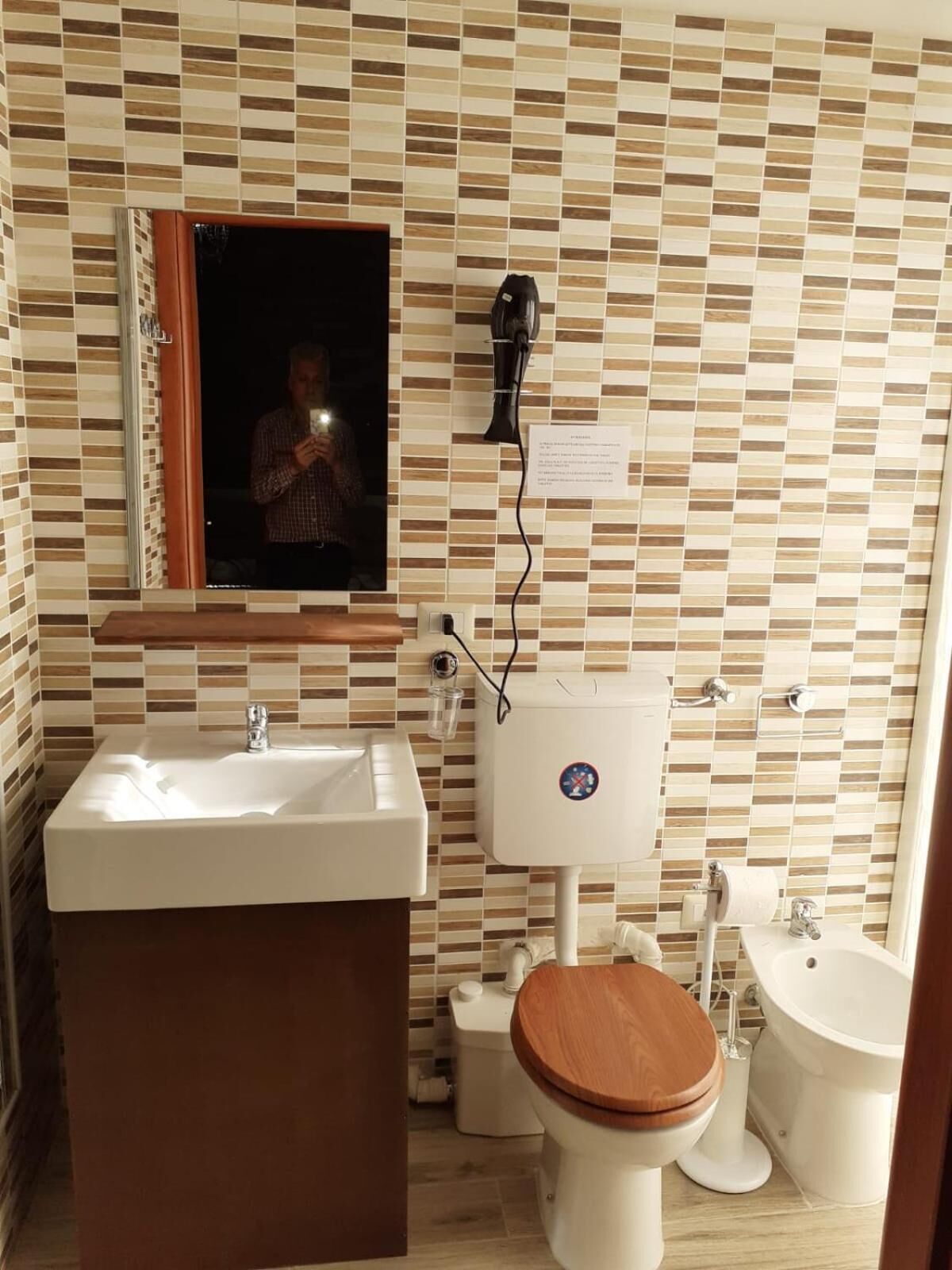 Un baño con detalles de azulejos, un lavabo, inodoro y espejo.