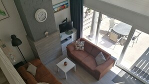 En moderne stue med en brun sofa, et hvidt sofabord og en pejs.