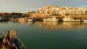 A harbor with boats docked, a fortified building in the background, and a clear sky. - Family friendly, parking, beach, high-speed wifi, excursions, sea view ... (Peñíscola)