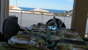 A table set for two with a view of the sea and a distant cityscape. - Family friendly, parking, beach, high-speed wifi, excursions, sea view ... (Peñíscola)