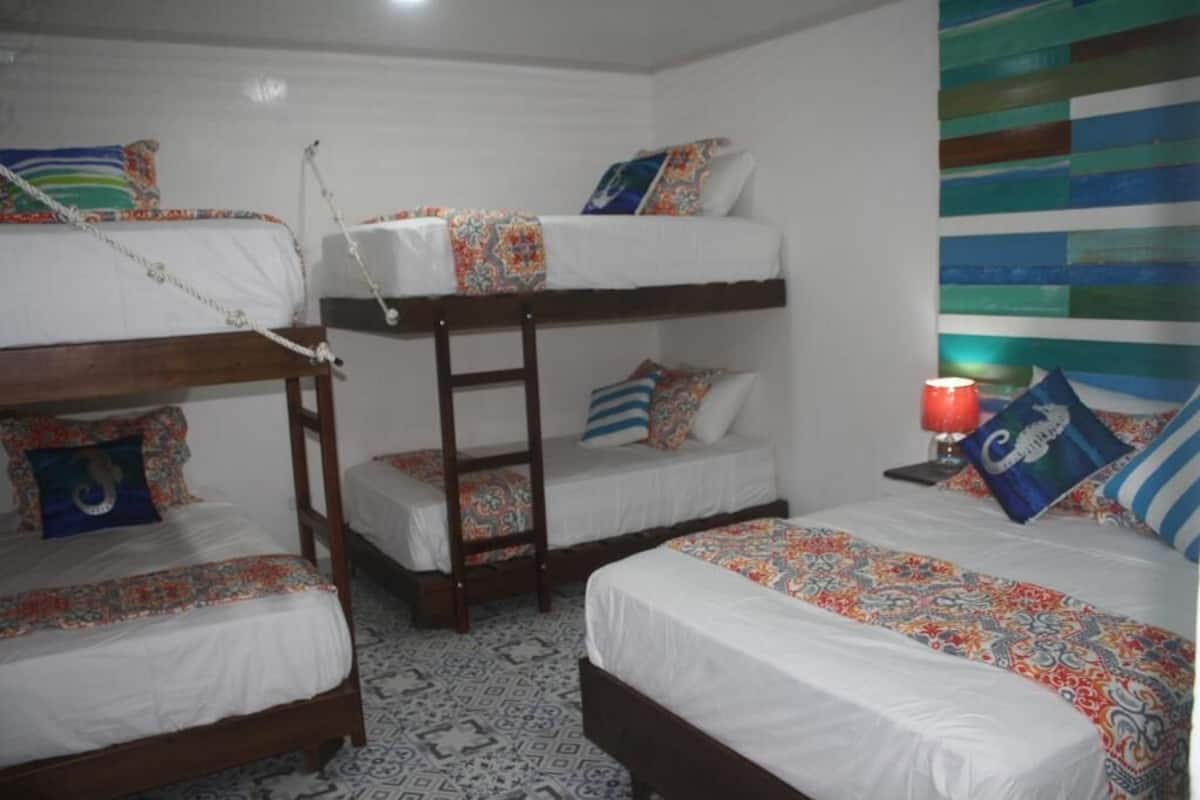 Quarto com beliches, roupa de cama estampada e design geométrico no chão.