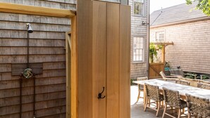 An open wooden door leading to an outdoor patio area with a table and chairs. - 100 Steps to Main Street. 5 bedrooms and 6.5 baths. New and Completely renovated (Nantucket)