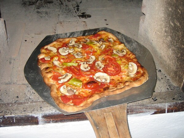 A pizza with various toppings on a metal tray.