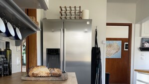 Een moderne keuken met een roestvrijstalen koelkast, een houten aanrecht en een brood.