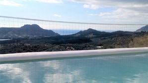 En pool med udsigt til et bjerglandskab og en klar himmel.
