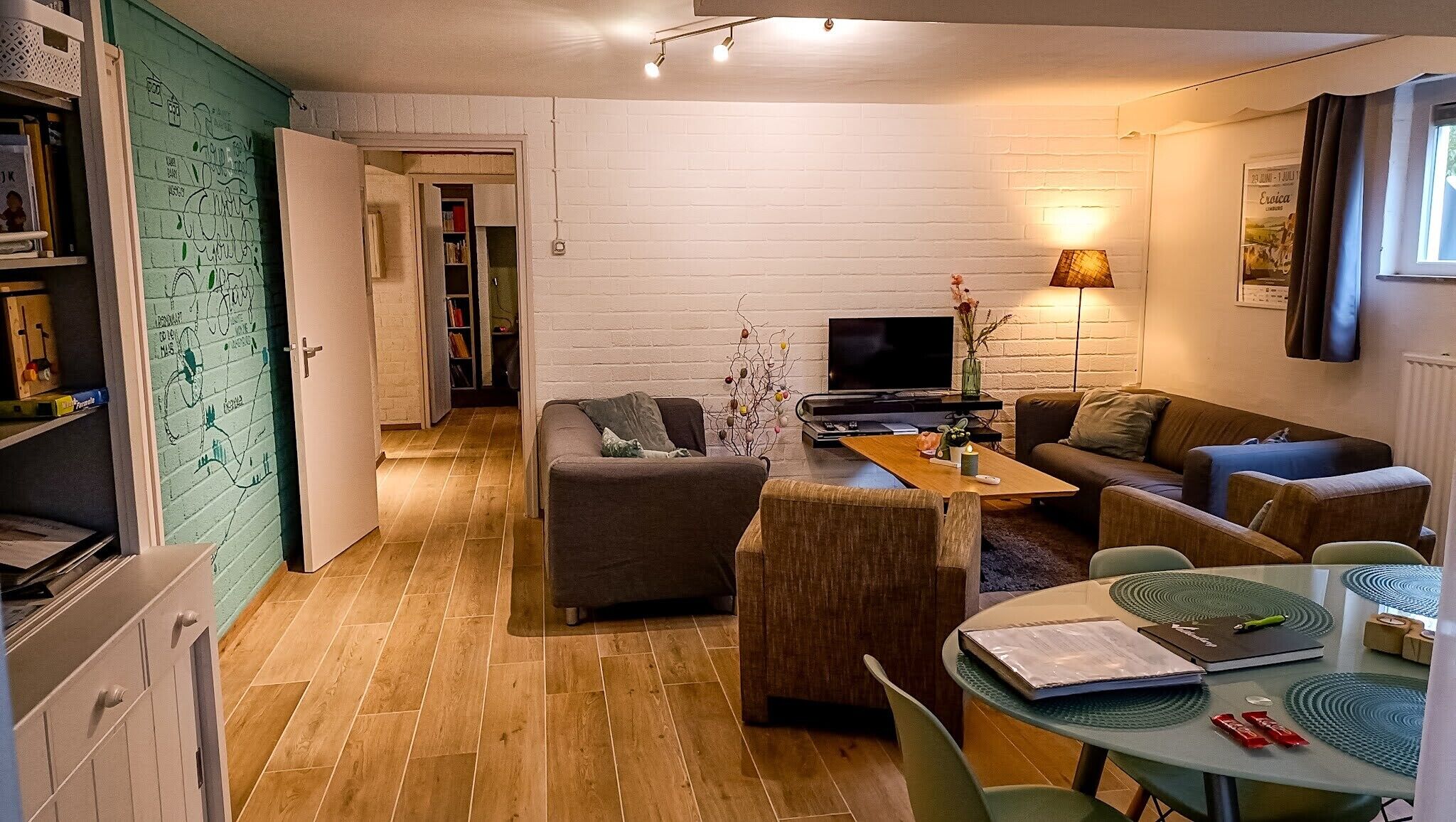 A compact living space with a sofa, a coffee table, a TV, and a dining area with a table and chairs.