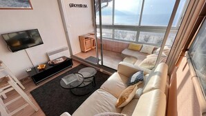 Uma sala de estar moderna com um sofá, uma mesa de centro e uma televisão.
