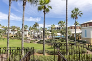 A resort with multiple buildings, palm trees, and a well-maintained lawn.