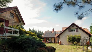Un quartier résidentiel comprenant deux maisons : l’une avec un toit en pente et des panneaux solaires, et l’autre avec un toit à deux versants plus traditionnel.