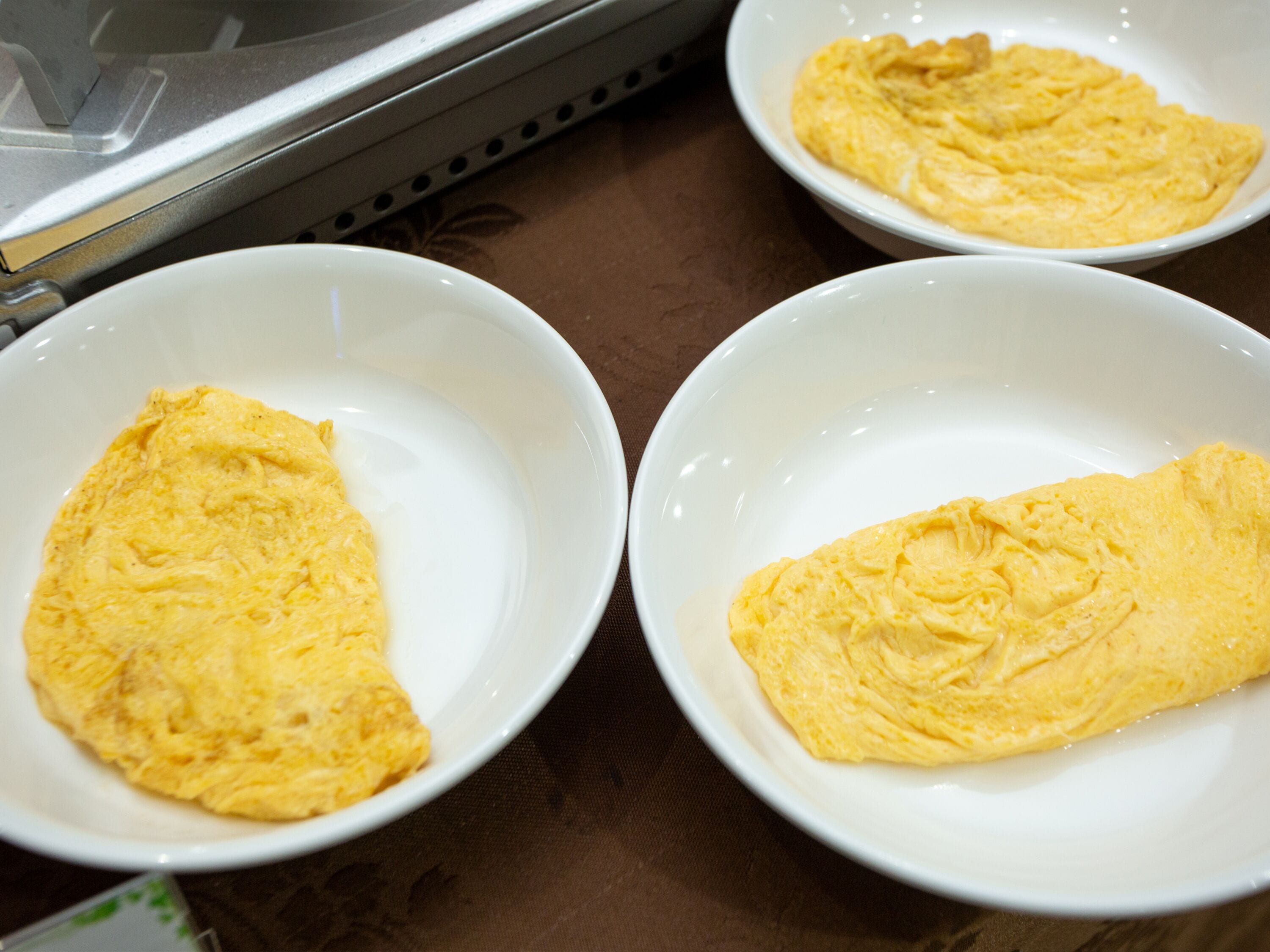Tres boles blancos con tortillas sobre una mesa.