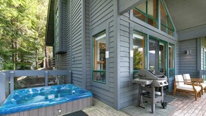 A deck with a hot tub, outdoor grill, and seating area. - Townhome w/ hot tub & AC near village (Whistler)