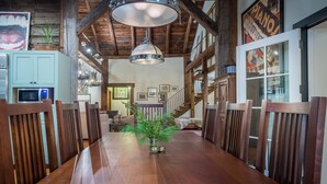 Ein Holztisch mit Stühlen, eine Pendelleuchte und ein Blumentopf.