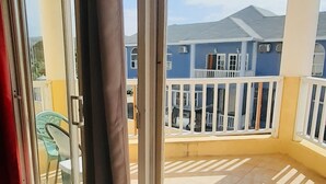 Ein Balkon mit Blick auf ein blaues Gebäude und Berge.