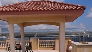 Une terrasse sur le toit avec un jacuzzi, des sièges extérieurs et une vue sur la mer.