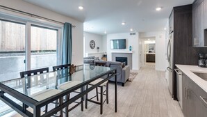 A modern kitchen with dark wood cabinets, a built-in oven, and a large refrigerator.