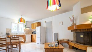 A spacious kitchen with wooden cabinets, a white refrigerator, and a dining area with a wooden table and chairs.