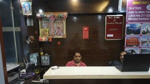 A reception desk with a computer, a monitor, and a sign indicating a checkout area. - ADB Rooms Hotel Chander Palace (New Delhi)