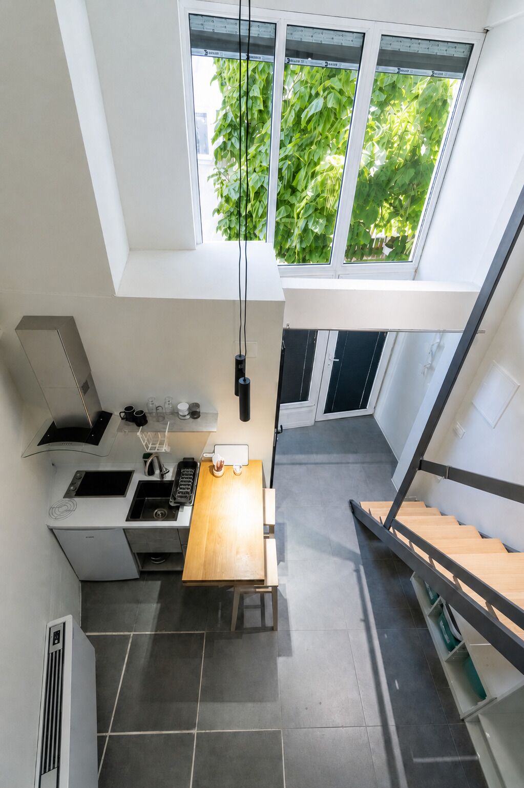 Een moderne keuken met een ingebouwde kookplaat, spoelbak en een houten eettafel.