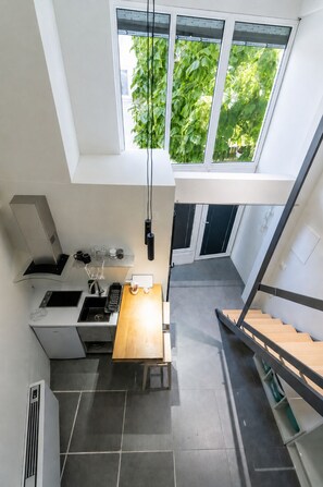 Una cocina moderna con estufa integrada, lavamanos y una mesa de comedor de madera.