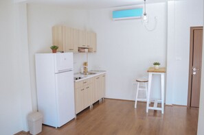 Comfort studio (2) | Privékitchenette | Een koelkast, een kookplaat, een waterkoker, kookgerei, borden en bestek