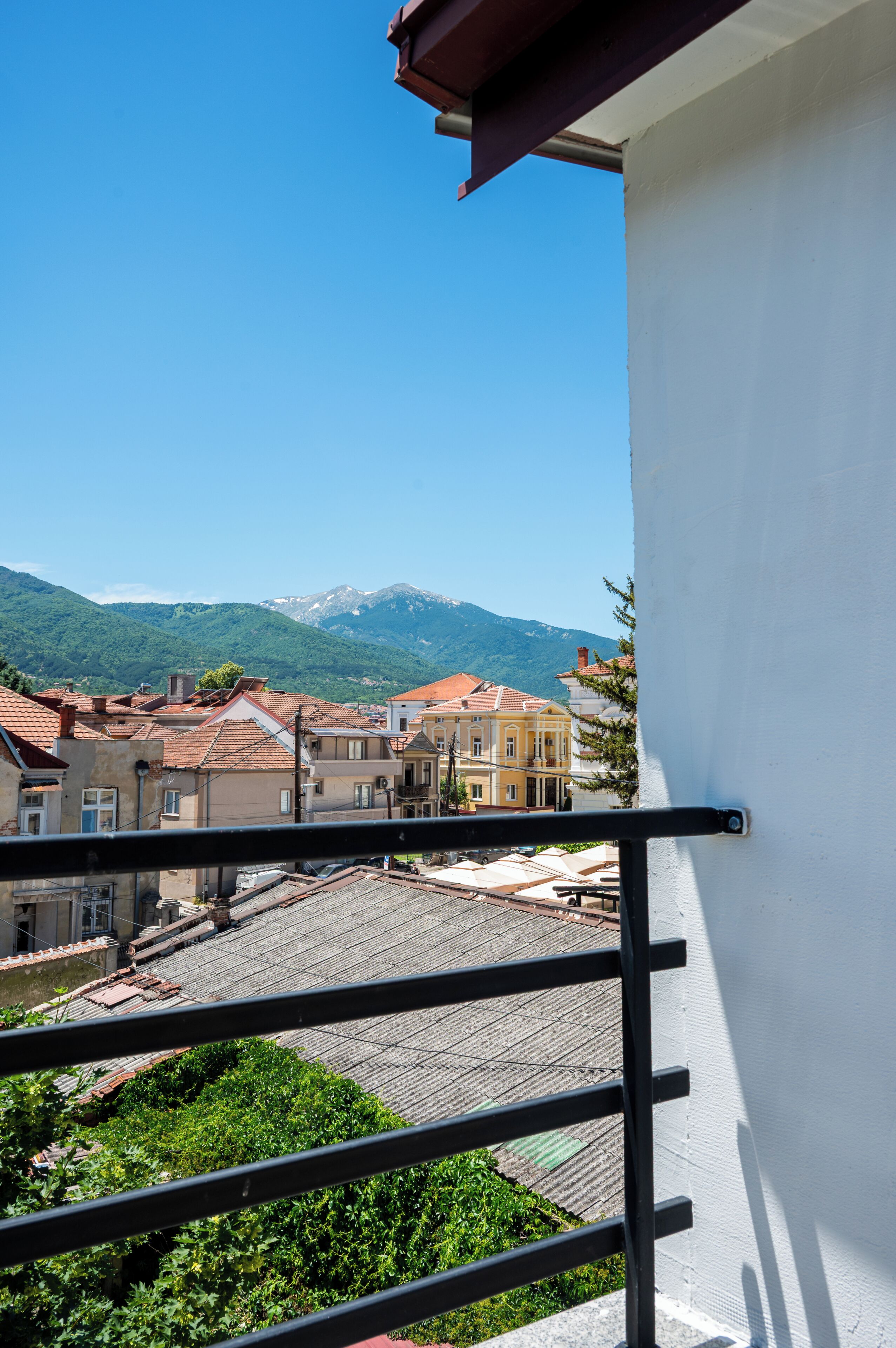 Un balcon avec vue sur la ville et les montagnes.