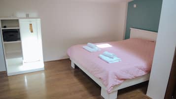 A bedroom with a bed, a wardrobe, and a shelf unit.