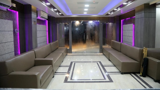 A modern spa room with a central seating area, a glass partition, and ambient lighting. - Hotel Nandini (Baharampur)