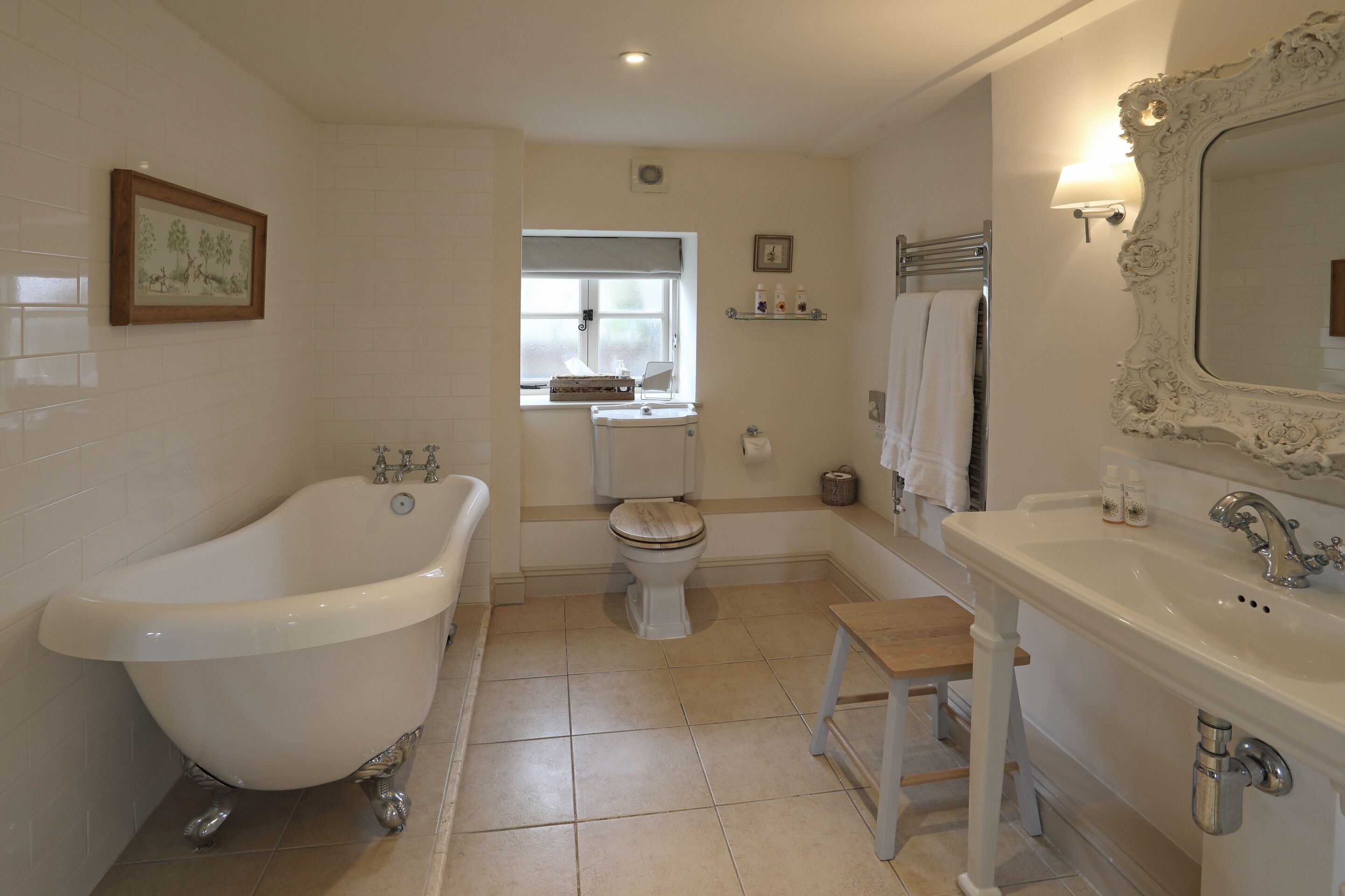 A bathroom with a freestanding bathtub, a toilet, a sink, and a vanity.