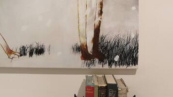 A bookshelf with books and a horse sculpture.