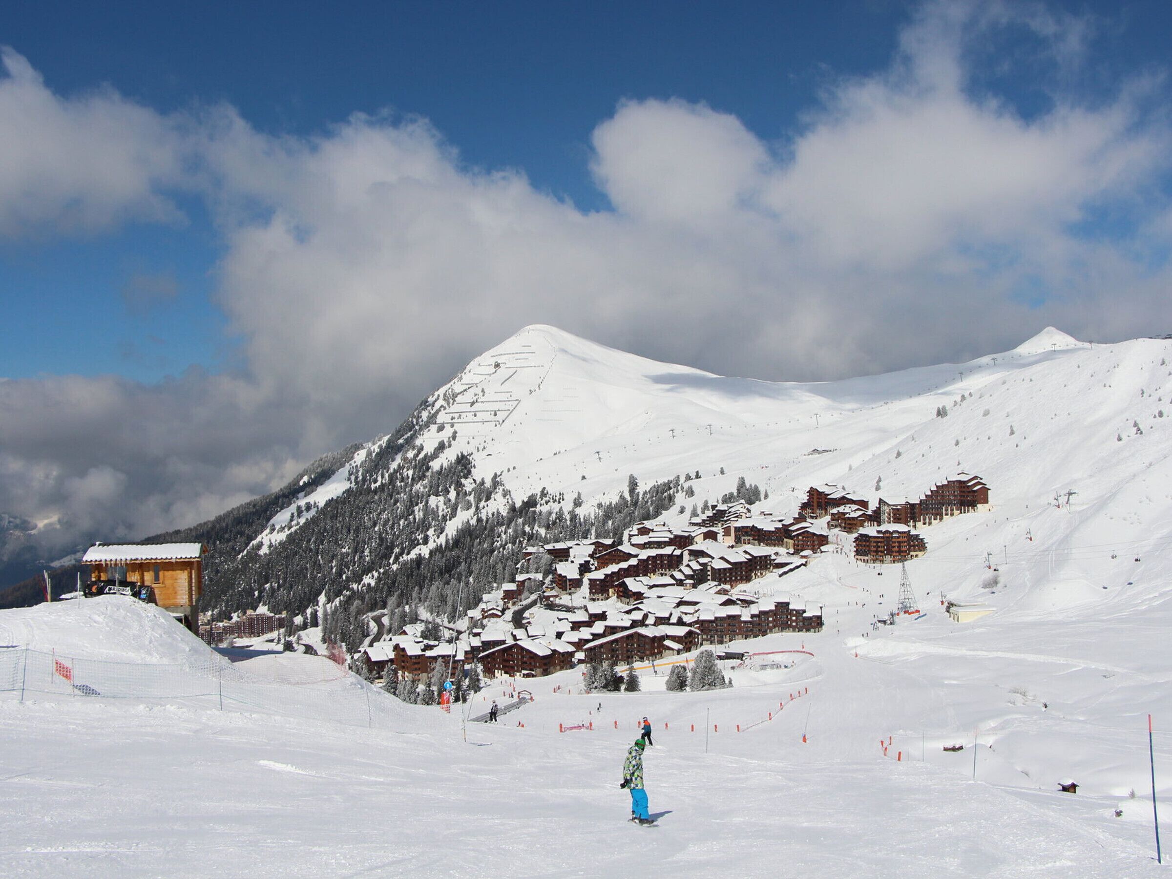 A snow-covered mountain with a ski resort, including buildings and ski slopes.