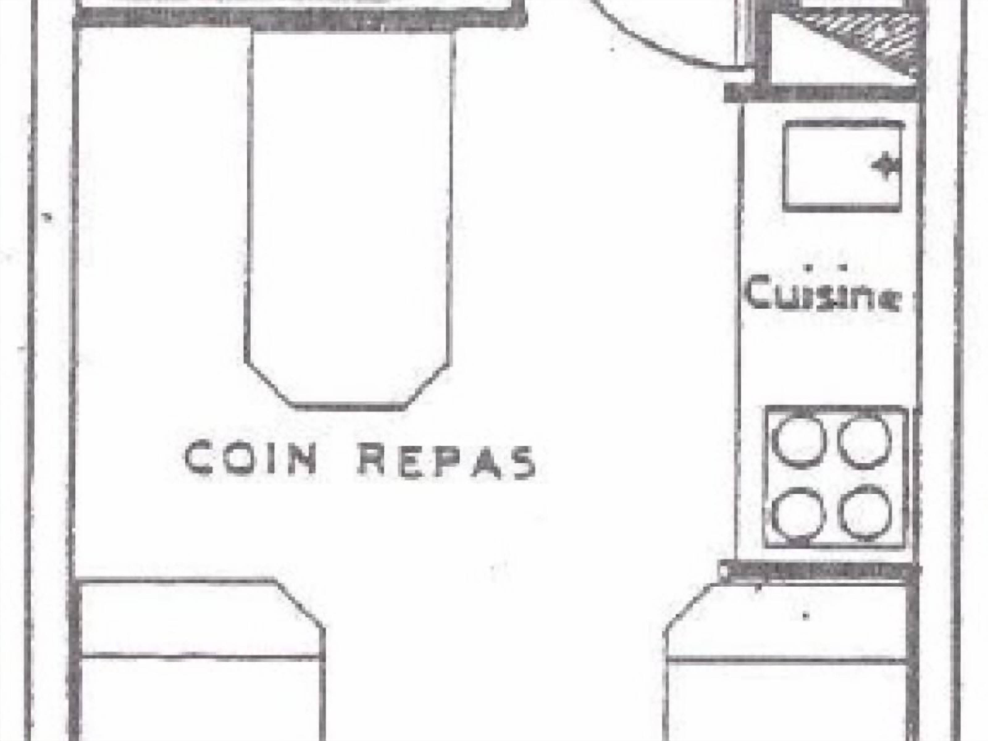 Un espace cuisine divisé en zones clairement identifiées, avec les panneaux « COIN REPAS » et « CUISINE ».