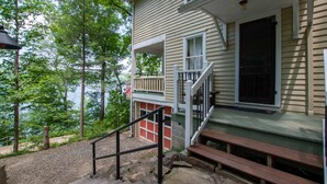 A house with a porch, a staircase, and a view of trees and water. - Ironwood: Amazing Keuka Lake Views! (Hammondsport)