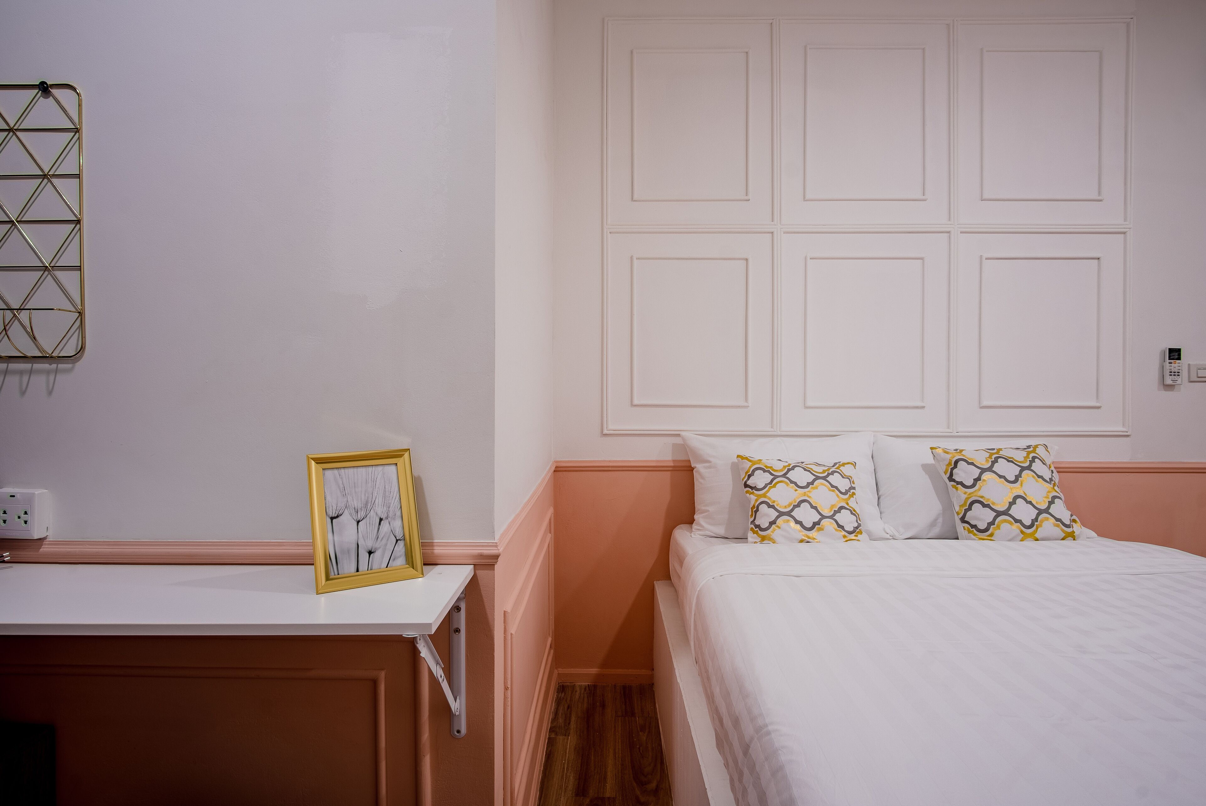 Une chambre à coucher comprenant un lit, une table de chevet et un luminaire fixé au mur.