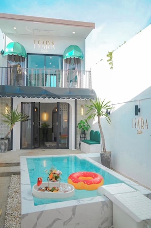 A modern hotel with a pool, outdoor seating, and a balcony with umbrellas. - Isara Boutique Hotel and Cafe (Phuket)