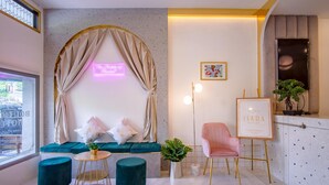 A modern interior with a seating area, a neon sign, a framed artwork, and a television.